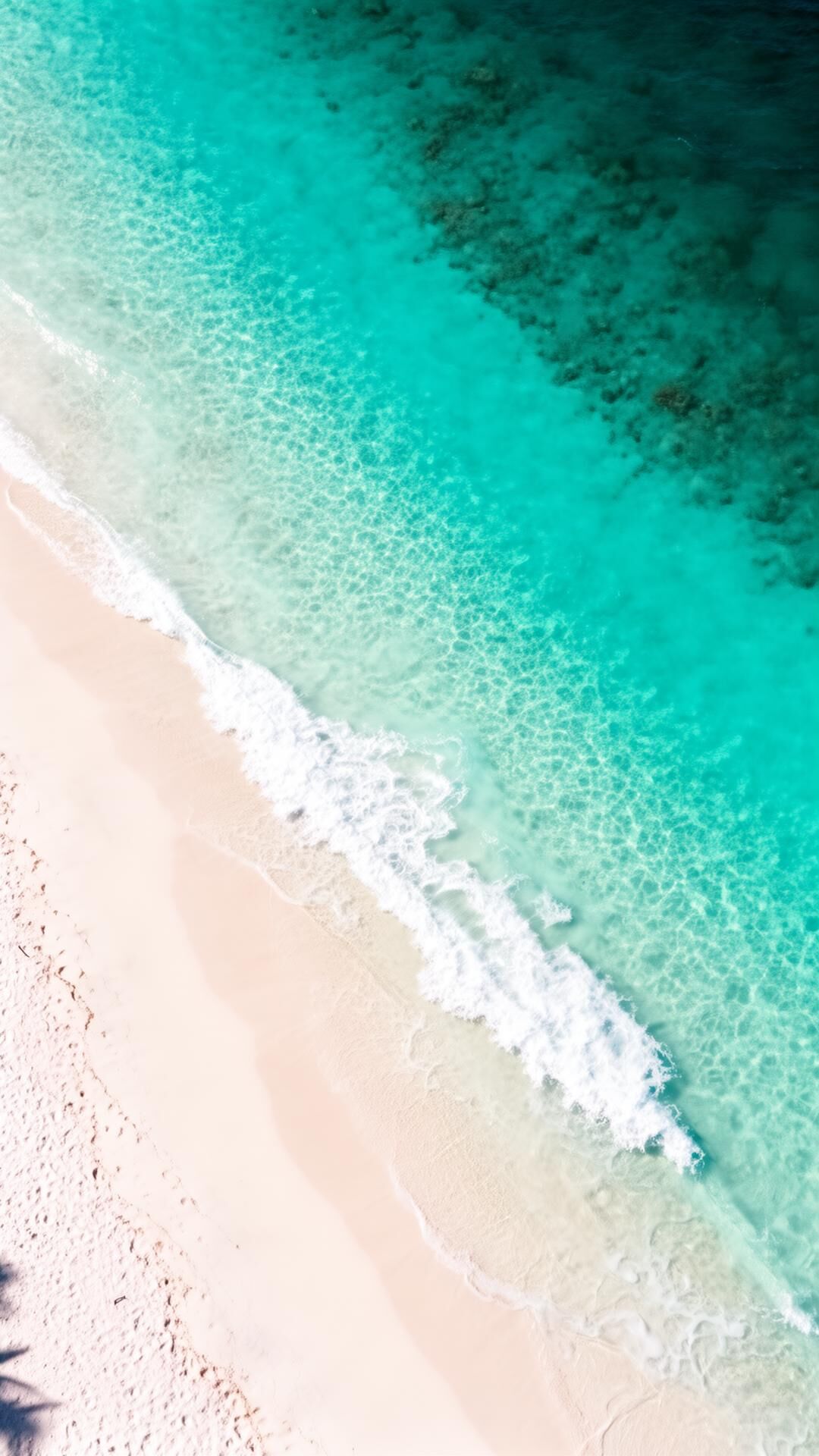 Aerial view of turquoise ocean meeting sand